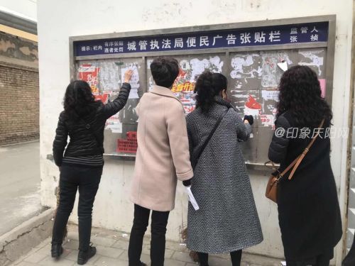 图2：巾帼志愿者铲除背街小巷墙面牛皮癣