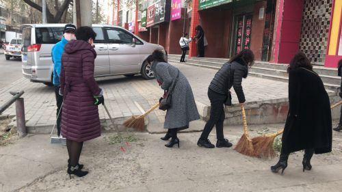 图3：巾帼志愿者清理背街小巷裸露垃圾