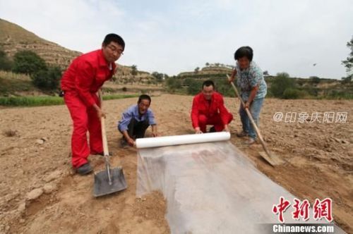 資料圖：春耕期間，長慶油田采油11廠駐村工作隊隊員幫助勞力不足的貧困戶開展地膜玉米種植。周沛龍 攝