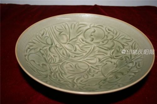 國家一級文物，宋代，出土于環(huán)縣虎洞鄉(xiāng)高廟灣村?？趶?4厘米，底徑6.4厘米，高7.8厘米，敞口，弧腹，圈足裸胎，灰白胎質(zhì)細(xì)膩堅(jiān)硬，釉色晶瑩溫潤，色澤青幽，口沿薄釉處呈姜黃色，碗內(nèi)壁一周弦紋下以寫實(shí)手法刻纏枝牡丹花紋，象征著富貴和美好的生活，多瓣式花朵刻劃得自然流暢，花紋棱角處因釉厚而呈翠綠色，外壁為自由式刻花圖案，刀法隨意。此碗造型精巧秀美，釉面光潔勻靜，刻花技法犀利流暢，紋飾寓意吉祥，是宋代耀州窯刻花瓷器的典范之作。