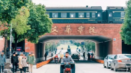 武漢一大學(xué)校門上跑火車？校方回應(yīng)：因地制宜，把火車涵洞作為校門