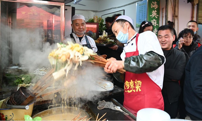 天水市秦州区的天水名优小吃城一麻辣烫店，商家为游客加工麻辣烫。新华社记者 范培珅 摄