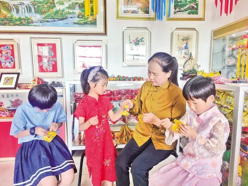 白淑方给小孩子教授香包刺绣技艺。
