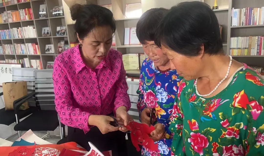 现场指导庄子峁村民和游客学习剪纸和刺绣技艺。