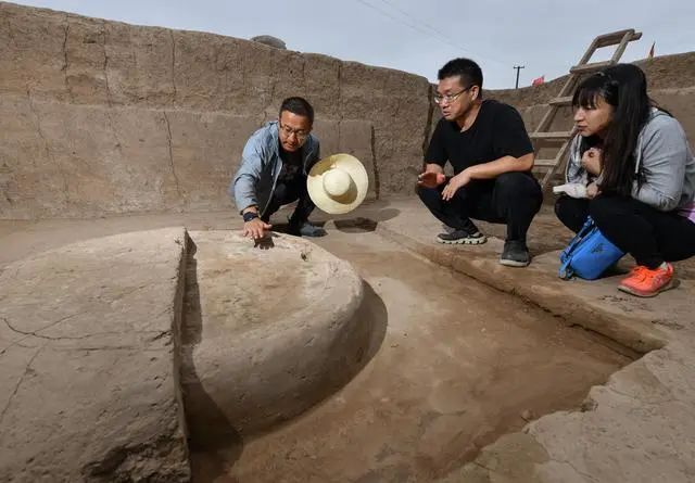 來自西北工業(yè)大學(xué)文化遺產(chǎn)研究院的考古隊員（左一）在南佐遺址核心區(qū)大型宮殿建筑發(fā)掘現(xiàn)場展示以&ldquo;白灰面&rdquo;鋪就的灶臺遺跡（2022年8月23日攝）。新華社記者 李賀 攝