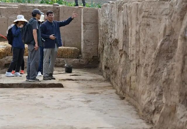 考古專家們在南佐遺址核心區(qū)大型宮殿建筑發(fā)掘現(xiàn)場考察（2022年8月23日攝）。新華社記者 李賀 攝