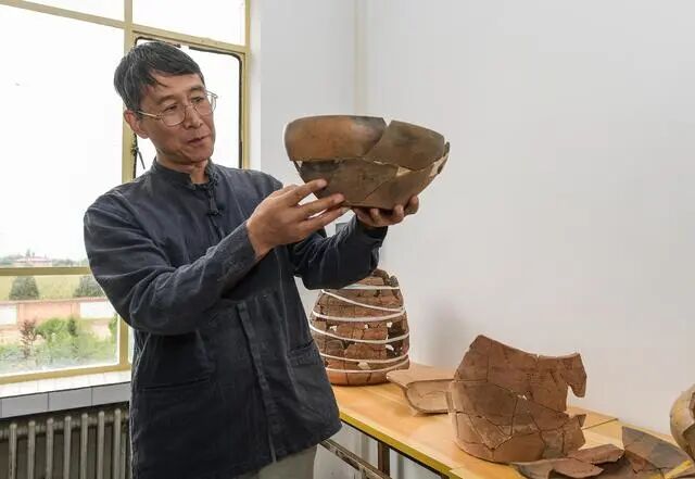 南佐遺址聯(lián)合考古隊領(lǐng)隊、中國人民大學(xué)歷史學(xué)院考古文博系教授韓建業(yè)在遺址研究基地內(nèi)展示出土的陶器（2022年8月23日攝）。新華社記者 李賀 攝