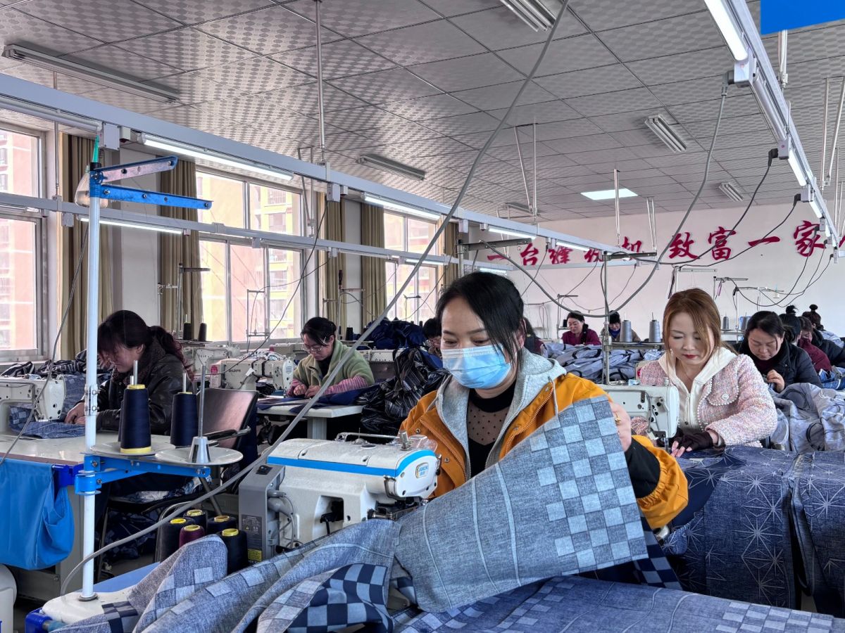 早勝鎮(zhèn)啟夢鄉(xiāng)村就業(yè)工廠車間內(nèi)工人縫制服裝