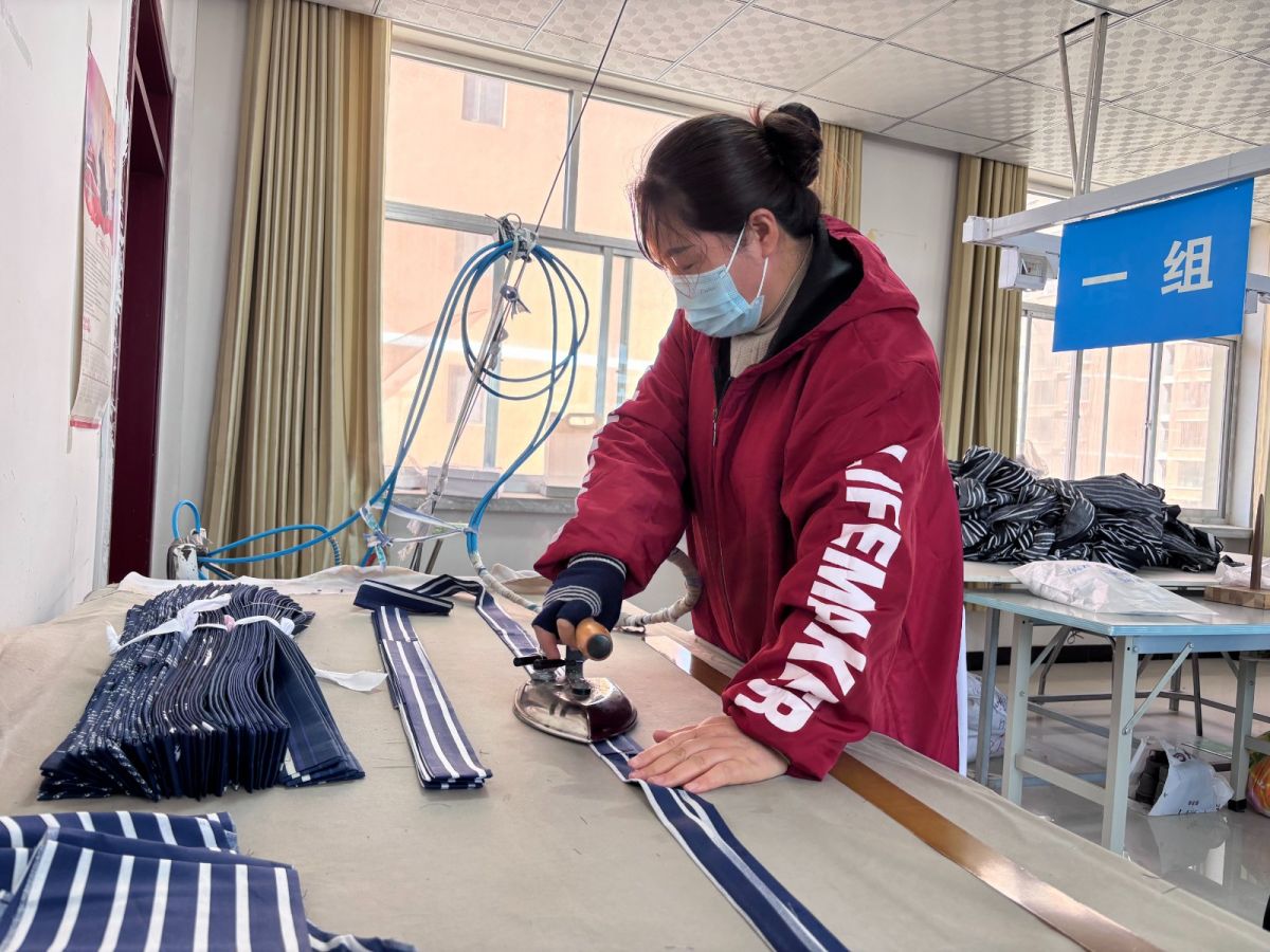 早勝鎮(zhèn)啟夢鄉(xiāng)村就業(yè)工廠內(nèi)工人熨燙服裝裁片