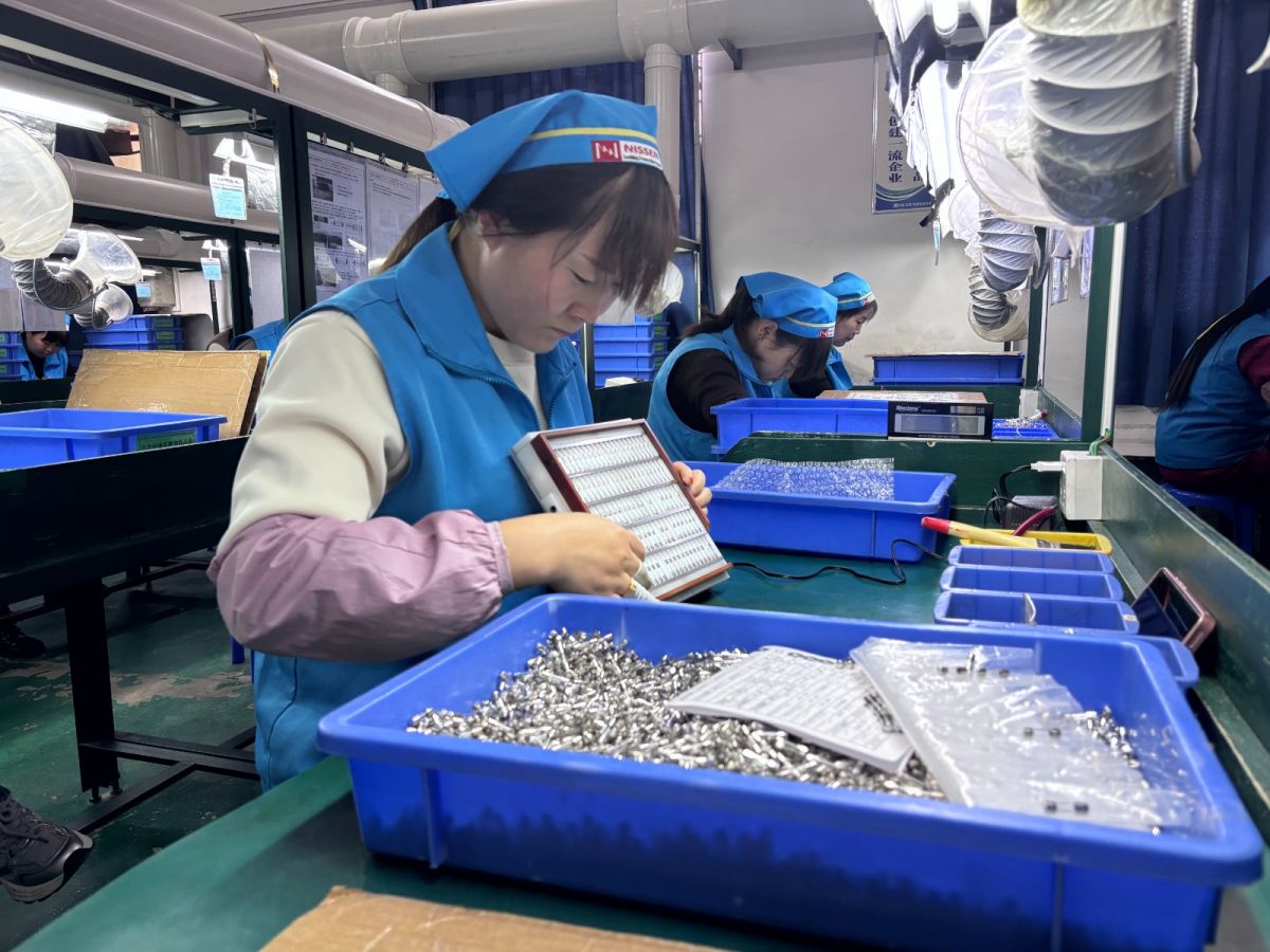 慶陽日線電器制造有限公司生產(chǎn)車間內(nèi)工人在篩選電流保險管