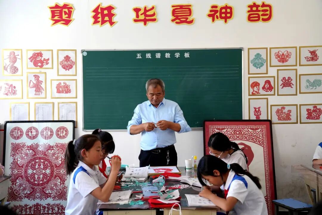 庆阳剪纸市级非遗代表性传承人赵东阳教学生剪纸。