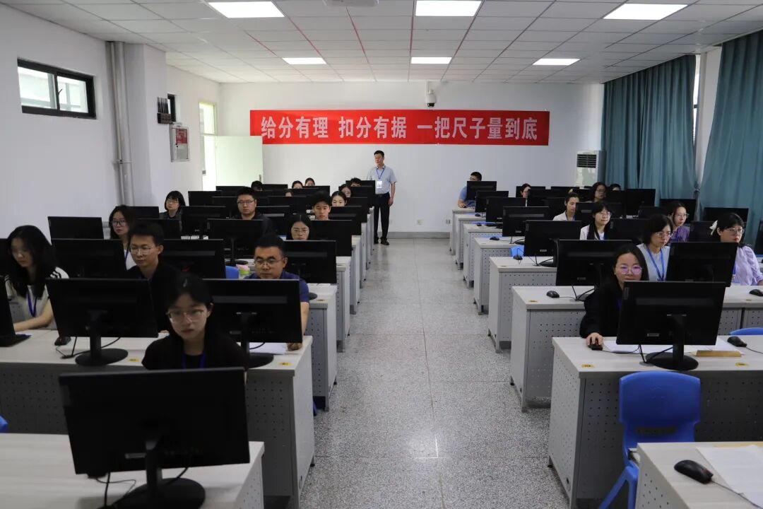 西北师大高考评卷点，评卷教师认真评阅试卷。