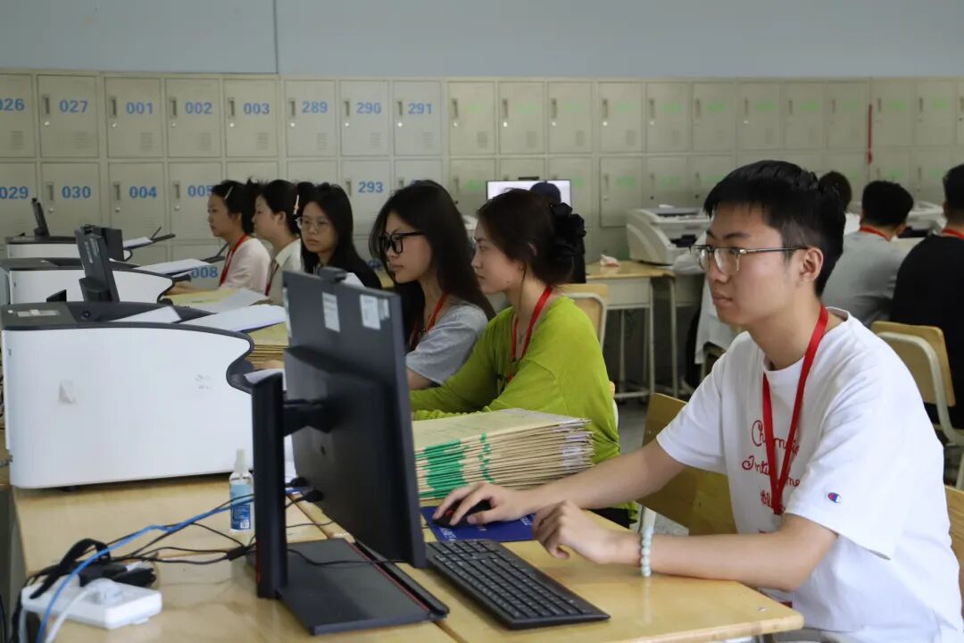 西北师大高考评卷点，评卷教师认真评阅试卷。