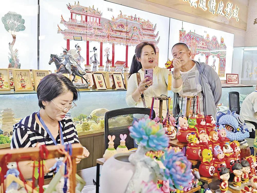 环县道情皮影馆内,游客选购面塑手工艺品。 庆阳融媒记者 俄少飞 摄