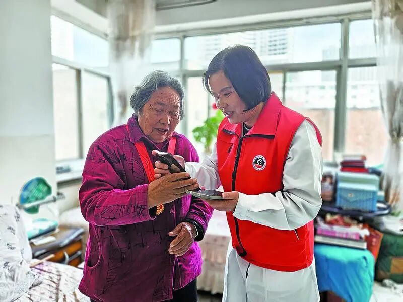 在高龄老人家中,“南丁格尔”奖获得者脱亚莉添加老人联系方式。通讯员 刘新艳 摄