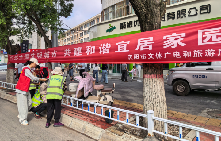 在安定东路街道人流密集处悬挂“创建全国文明城市 共建和谐宜居家园”的宣传标语。