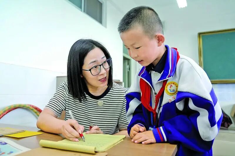 天津市红桥区第二实验小学副校长陈宝琳在合水县乐蟠小学给学生辅导作业。