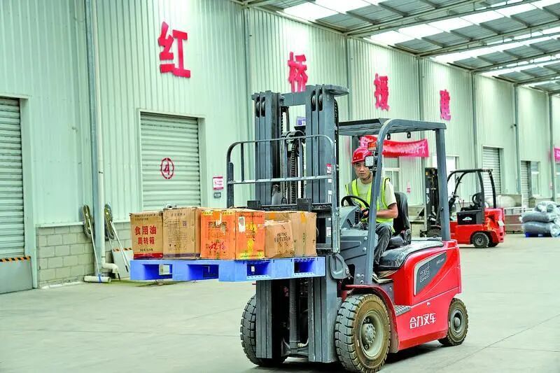 合水县津甘共建电商产业园内,工人运输货物。