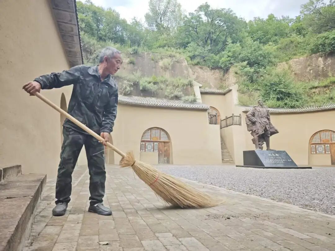 王文春清扫旧址院子。庆阳融媒记者 陈思 摄