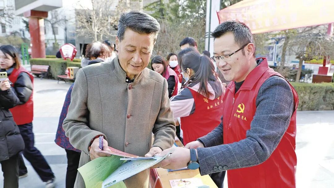 庆城县志愿者为市民发放创城宣传资料