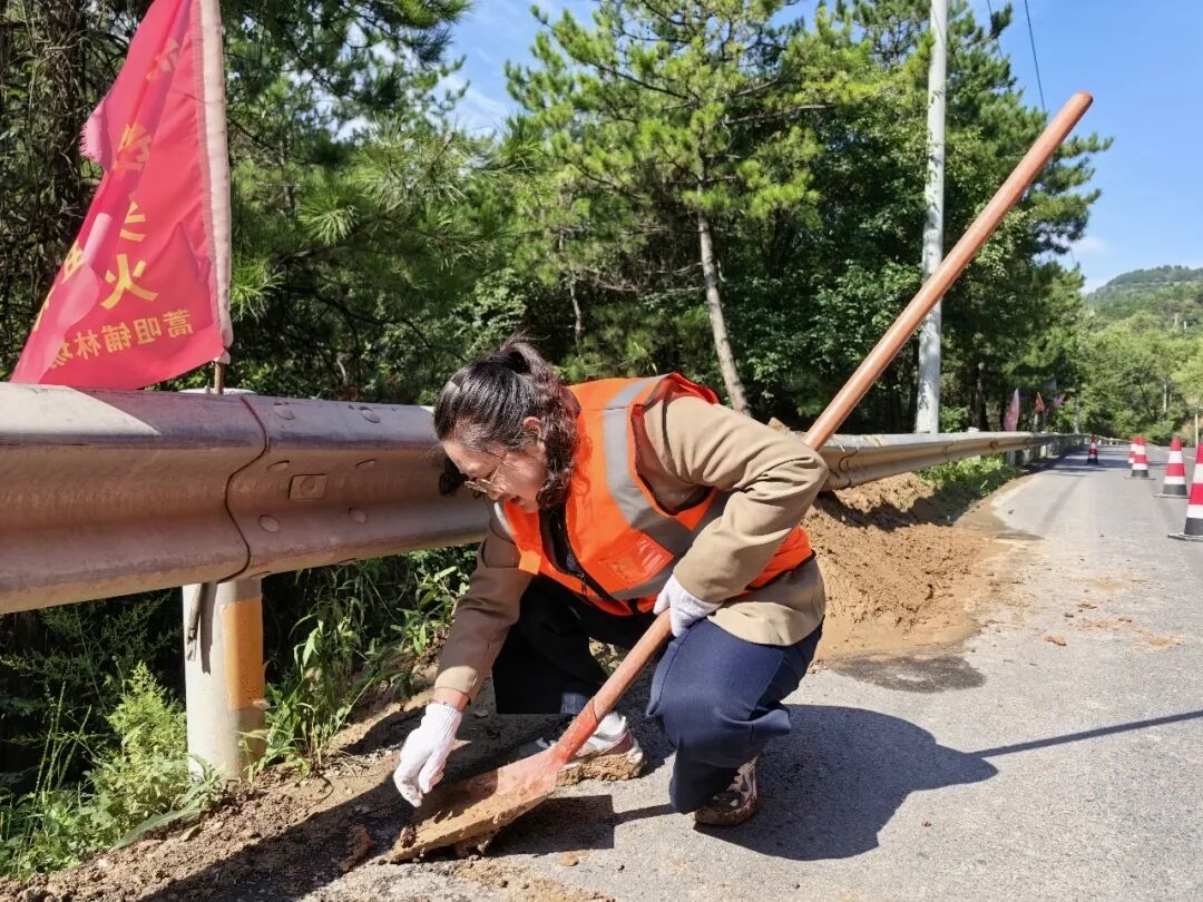 ▲秦玉霞在国道309线蒿咀铺路段清理工具
