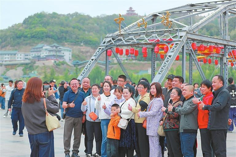 五一假期，游客在兰州中山桥合影留念。（通讯员陈坤）