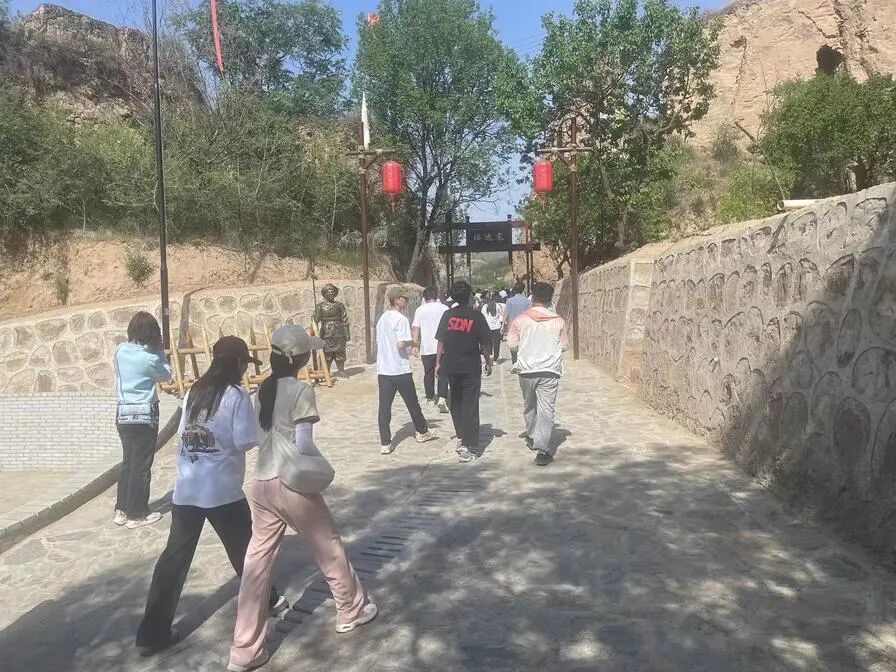 游客沿石板路步入骆驼城南瓮城入口,仿古城门与石砌步道相映成趣