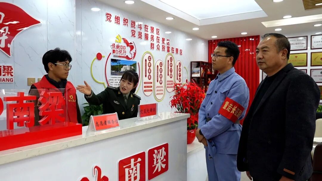 南梁红色大景区党群服务中心内,志愿者为游客提供引导。